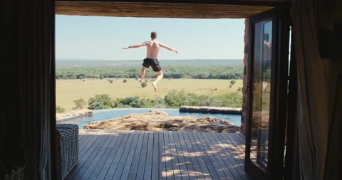 Man jumps into an infity pool Stock Footage 134294719