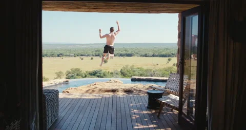 Man jumps into an infity pool Stock Footage 134296252