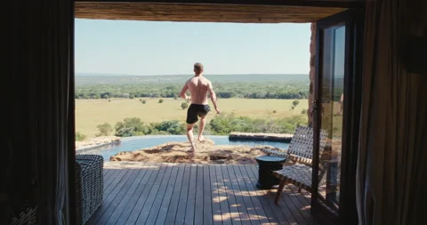 Man jumps into an infity pool Stock Footage 134296440