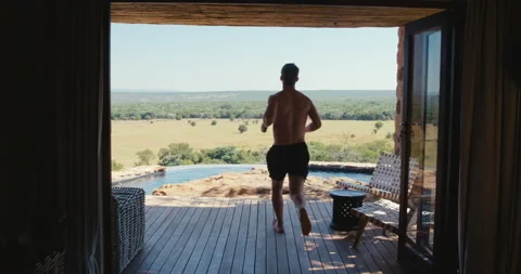 Man jumps into an infity pool Stock Footage 134297038