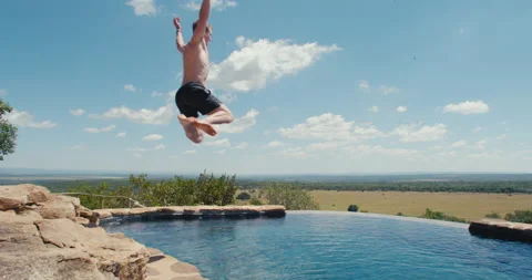 Man jumps into an infity pool Stock Footage 134305808