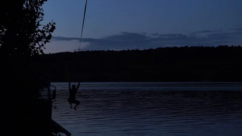 A man jumps at night into the water Stock Footage 114631007