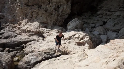 Man jumps from one stone to another and stops Stock Footage 103075223