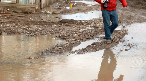 A man jumps over a puddles Stock Footage 65285975