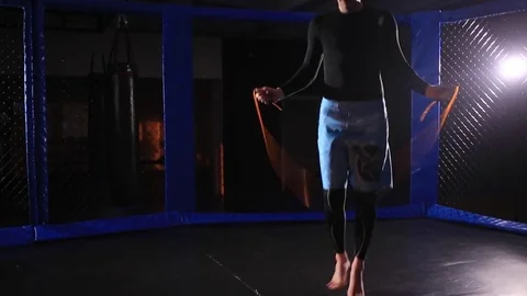 Man jumps on a skipping rope in a cage for MMA Stock Footage 71650902