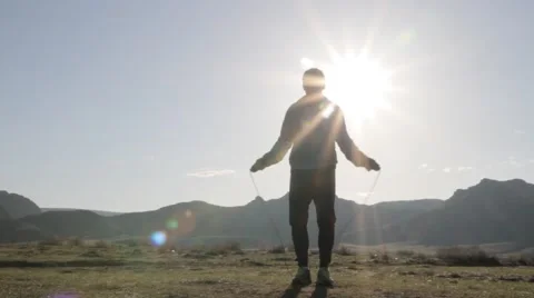 Man jumps through the rope against the background of sunlight Stock Footage 61648013