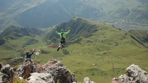 A man jumps off the top of the mountain. Video stock 97766330