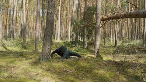 A man jumps from a tree in the forest and breaks his leg Stock Footage 191907383