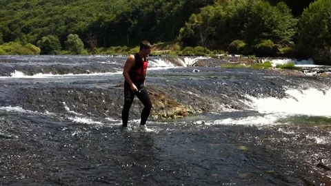 A man jumps into the waterfall Stock Footage 98033737