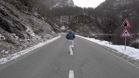 Man jumps on the winter road Stock Footage 96381733