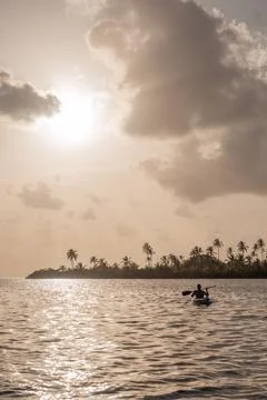 Man kayaking during sunset in a calm sea Stock Photos