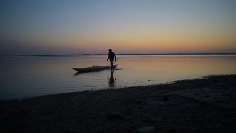 Man kayaking on lake during sunset Stock Footage 82356085