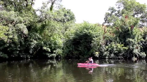 Man kayaking with train passing behind him Stock Footage 40496366