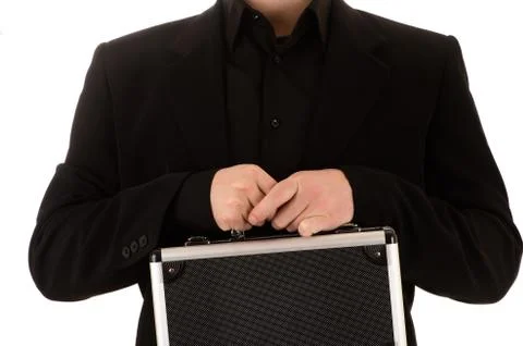 Man keeps in a black jacket and a black shirt before himself a metal case Stock Photos