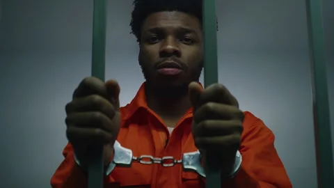 Man keeps hands in handcuffs on jail cell bars Stock Footage 246954618