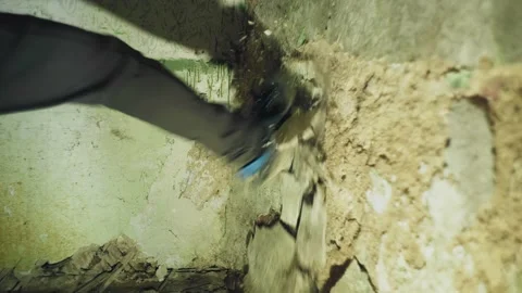 A man kicks an old wall and plaster falls off it. Shooting in slow motion Stock Footage 229340572