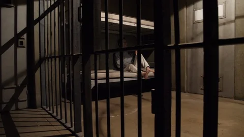 MAN KILLING TIME IN A JAIL CELL, MODEL RELEASE Stock Footage