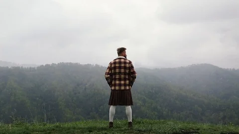 Man kilt with mustache beard mountain. looking back. snow. fog Caucasian Stock Footage 110100226