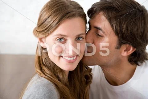 Man Kissing A Woman On The Cheek