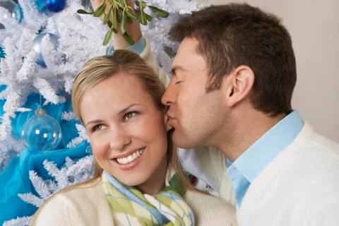 Man Kissing Woman Under Mistletoe Stock Photos