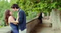 man kissing young woman , there is a mature couple in love in background HD Footage