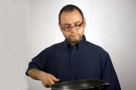 Man with kitchen accessories on white Stock Photos