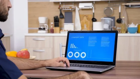 Man in the kitchen analyzing company data Stock Footage 97275596