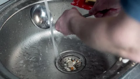 Man in the kitchen approaching a dirty sink washing the dishes. Stock Footage 251853744