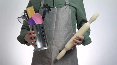 A man in a kitchen apron holds in his hands the inventory for cooking a dish Stock Footage 311540791