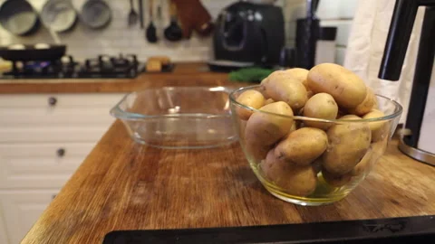 A man is in the kitchen baking young potatoes 스톡 동영상 274894324