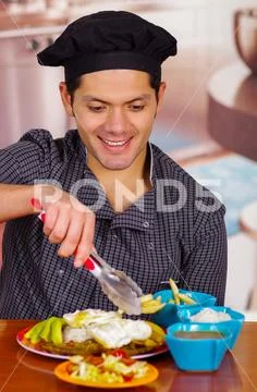 Man in kitchen cooking dish, churrasco ecuatorian cuisine Stock-Fotos
