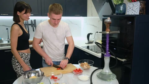 Man in Kitchen Cuts Cherry Tomatoes with Knife. Ingredients. Prepares Salad Stock Footage 147168084