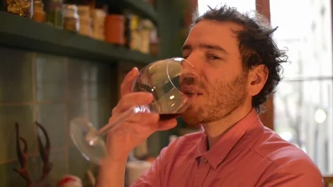 A Man in a Kitchen drink taste and sniff smell a Glass of Wine alone Video stock 84384727
