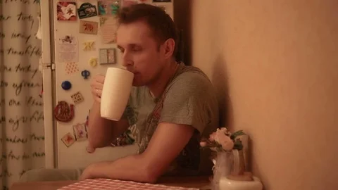 The man in the kitchen is drinking tea Stock Footage 82184864