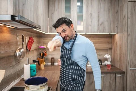 Man in the kitchen having fun while cooking Stock Photos
