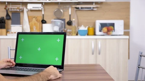 Man at the kitchen looking at laptop with green screen mock up Stock Footage 97266580