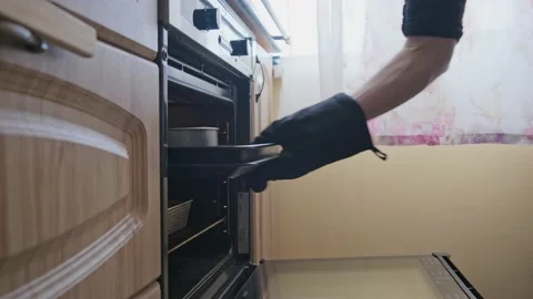 The man in the kitchen opens the oven and checks the baking sheet Stock Footage 165003126