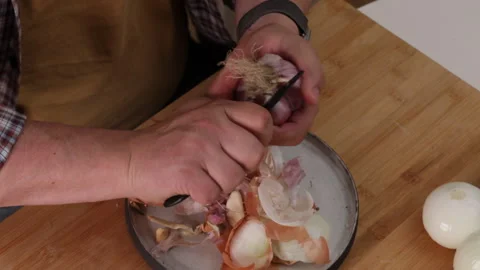Man in the kitchen peeling onions Stock Footage 289174874