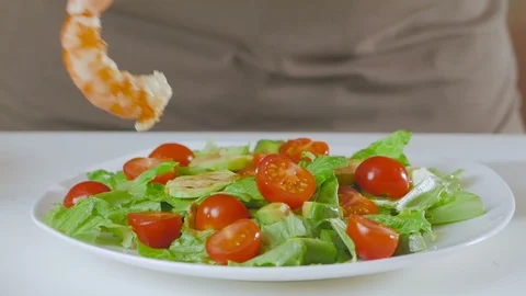 A man in the kitchen prepares a salad of avocado, zucchini and cherry tomatoes Stock Footage 101818365