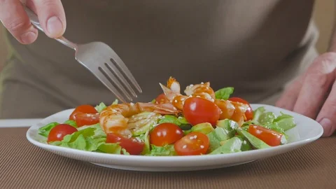 A man in the kitchen prepares a salad of avocado, zucchini and cherry tomatoes Video stock 101818760