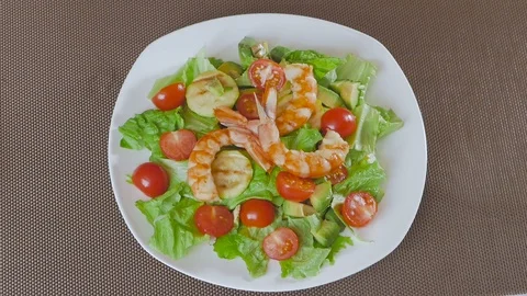 A man in the kitchen preparing a salad of avocado, zucchini and cherry tomatoes Stock Footage 101818512