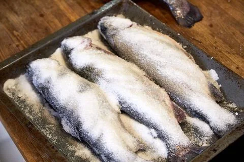  a man in the kitchen sink cutting up a fish. View from above, close-up of hands Stock Photos