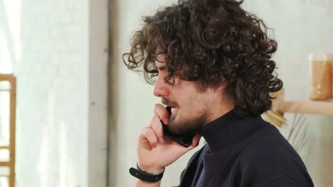 Man on kitchen is smiling, drinking coffee and talking on a smart phone. Stock Footage 153165258