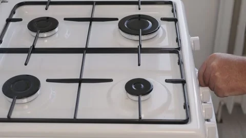 A Man in the Kitchen Stops the Gas Cooker using the Front Button and Closing the Stock Footage 348097565