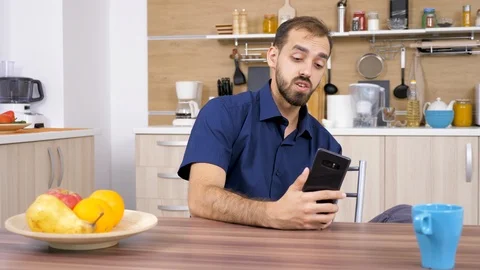 Man in the kitchen talking with somebody on the phone Stock Footage 97285356