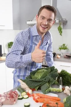 Man in the kitchen with thumb up preparing dinner. Foto stock