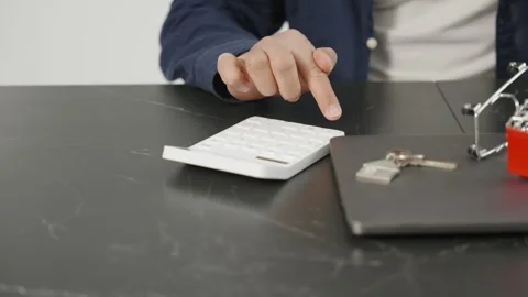 A man at kitchen using a calculator and taking notes Video stock 333982100
