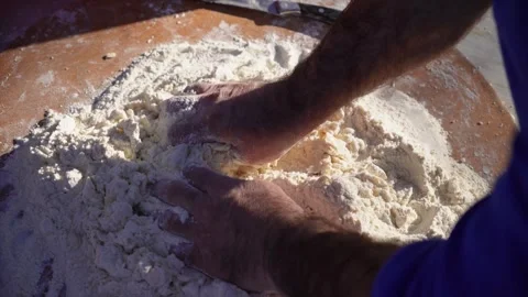 Man kneading dough in flour on large board with bare hands, close up of hands  Vídeos de archivo 312977547