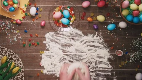 Man kneading dough on table decorated with easter eggs. Top view Stock Footage 73945949
