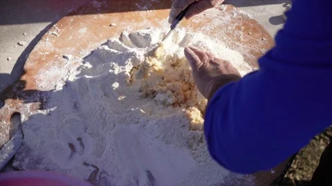 Man kneading egg into dough with knife, cooking outdoors Vídeos de archivo 312977559